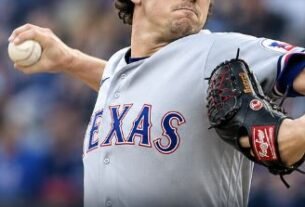 Cal Quantrill of the Texas Rangers pitching during the game against the Seattle Mariners, wearing a gray Rangers uniform and blue cap.
